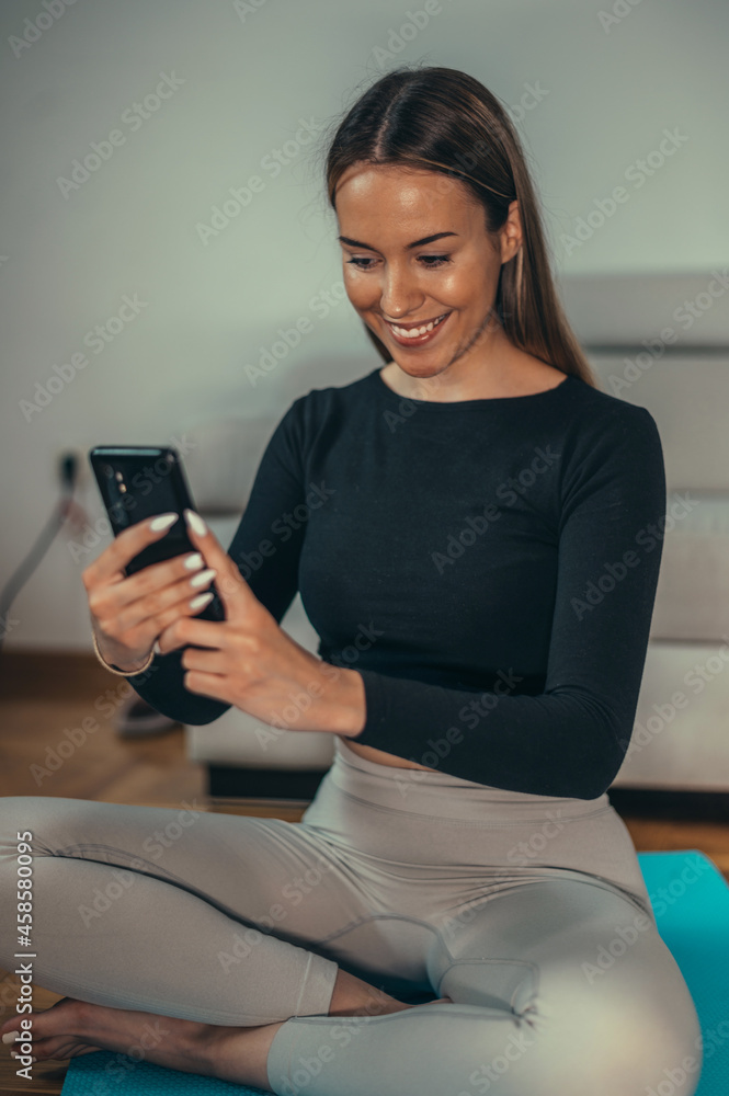 Woman taking selfie with her smartphone while training at home Woman taking selfie with her smartphone while training at home