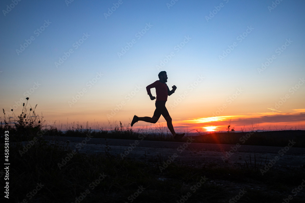 active man silhouette running at sunset