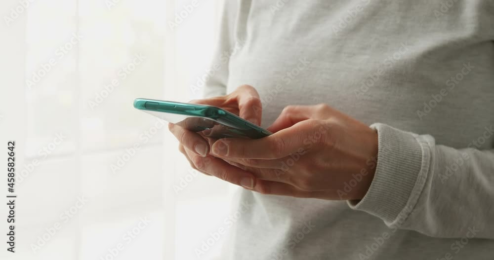 The woman uses a mobile phone on social networks. Smartphone in hand. Close-up. The woman uses a mobile phone on social networks. Smartphone in hand. Close-up.