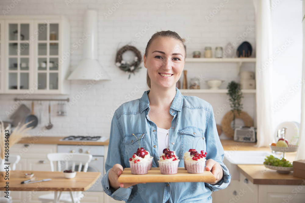 Lifestyle, food, people and small business concept: Young baker woman holding cupcakes. Lifestyle, food, people and small business concept: Young baker woman holding cupcakes.