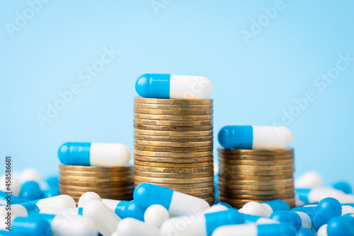 Fotografía Stacks of coins between medical pills capsules