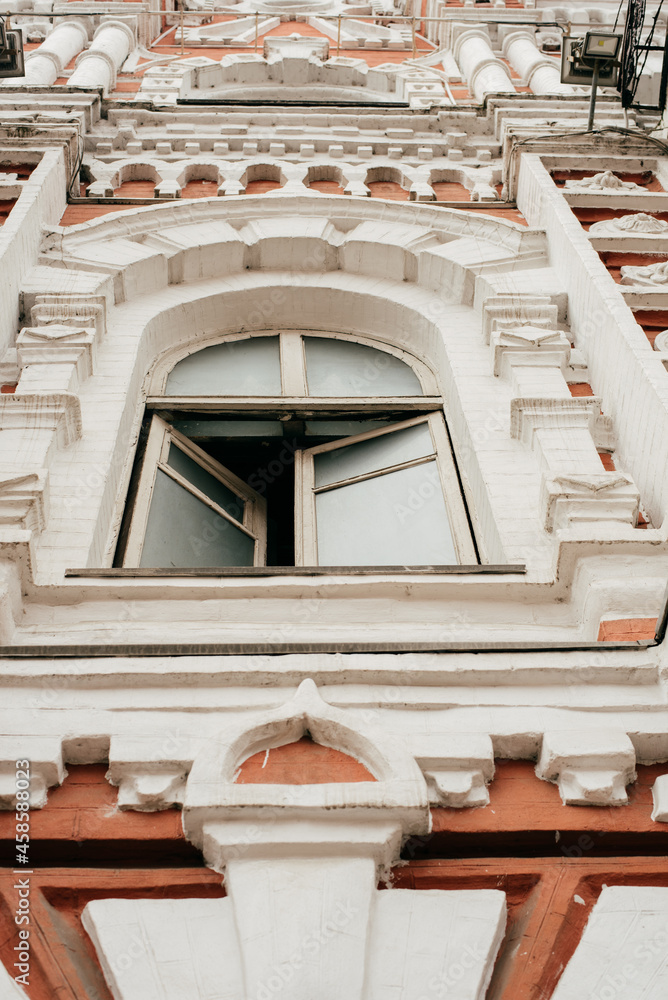 an ornate detail of an old historic building above the open window 