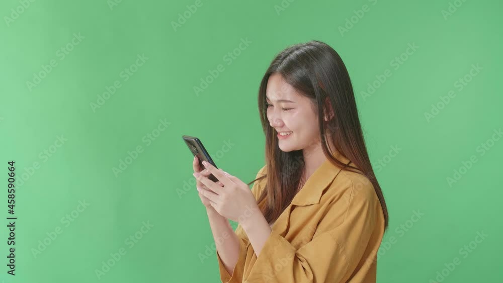 Side View Of Happy Young Asian Woman Use Mobile Phone While Standing On Green Screen In The Studio
Side View Of Happy Young Asian Woman Use Mobile Phone While Standing On Green Screen In The Studio