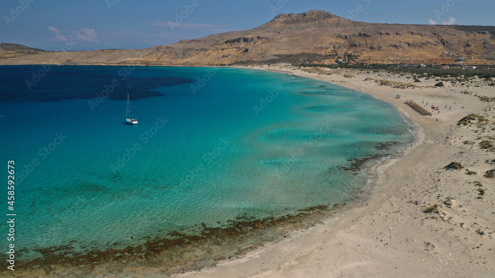 Aerial drone photo of paradise turquoise sandy beach and bay of Simos in island of Elafonisos visited by yachts and sail boats, South Peloponnese, Lakonia, Greece