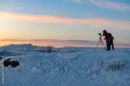 Photographer at sunrise in Thingvellir National Park in Iceland in the winter