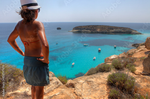 Tableau sur toile Girl in front of the Island of Rabbits in Lampedusa, Sicily, Italy