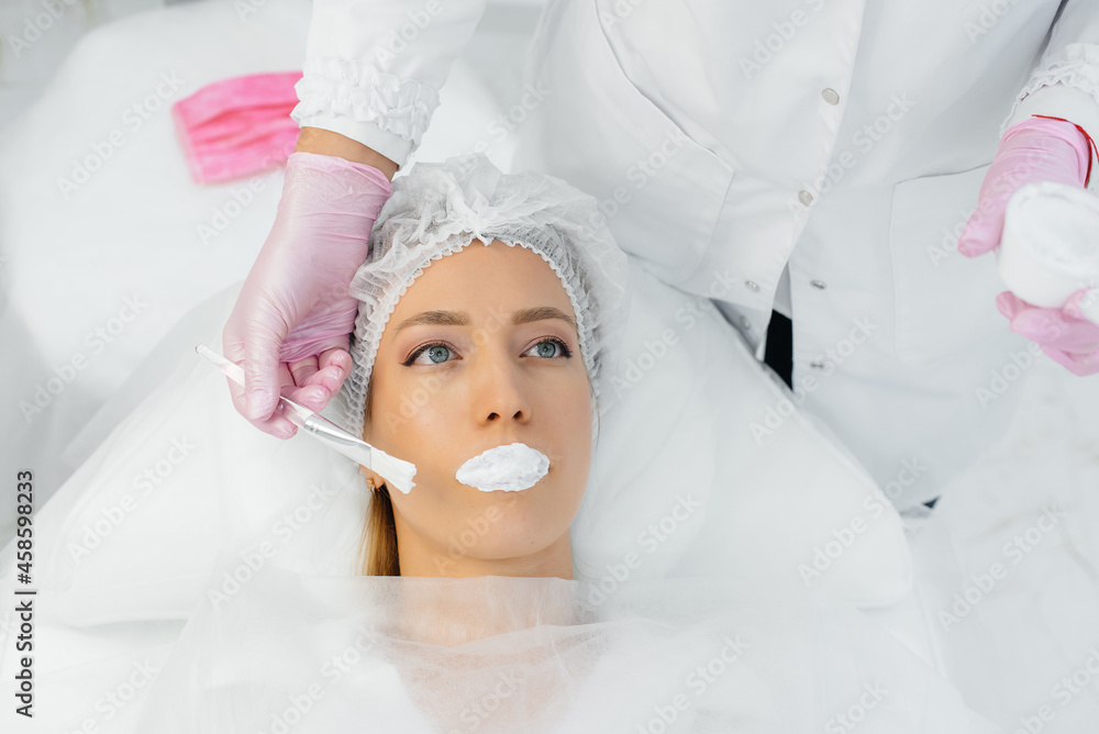 Moisturizing the lips during a cosmetic procedure for a young girl. Cosmetology