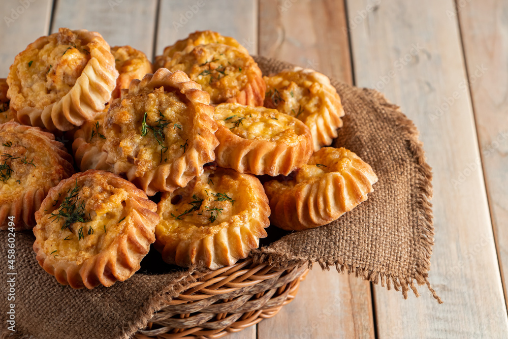 Basket with fresh muffins on wooden background. Homemade cakes with vegetables and cheese. Recipe for autumn seasonal dish.