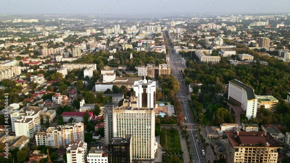 Aerial drone view of Chisinau downtown. Panorama view of multiple buildings, Parliament, Presidency, roads with moving cars and lush trees. Sunset. Moldova Aerial drone view of Chisinau downtown. Panorama view of multiple buildings, Parliament, Presidency, roads with moving cars and lush trees. Sunset. Moldova