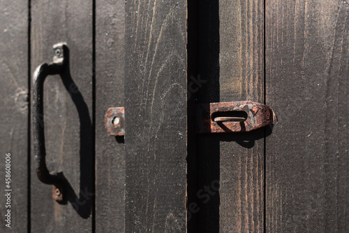 Closeup shot of an old wooden barndoor with a rusty metallic lock photo