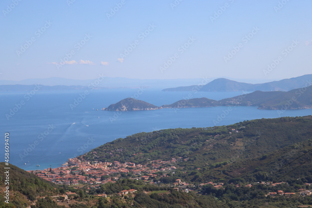 Elba, Italy – September 01, 2021: beautiful places from Elba Island. Aerial  view to the island. Little famous villages near the beaches. Summer tourist places. Clouds and blue sky in the background.