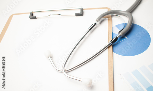 Stethoscope with blue charts on the white background