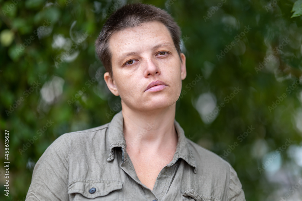sad woman in paramilitary uniform with tired face walking through park