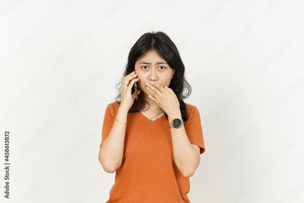 Talking on the phone and get bad news of beautiful asian woman Wearing orange T-shirt isolated on white background Talking on the phone and get bad news of beautiful asian woman Wearing orange T-shirt isolated on white background