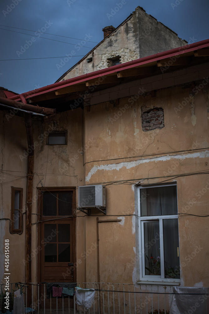 poor district for living with old building slum object exterior cracked wall and dirty facade, moody vertical unsaturated photo