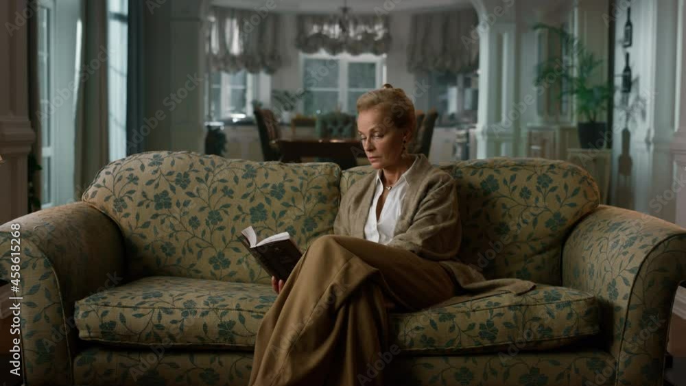 Old aged woman reading book in luxury living room. Elegant lady having rest Old aged woman reading book in luxury living room. Elegant lady having rest