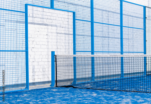 Paddle tennis and tennis net on blue court. Tennis competion concept. Horizontal sport poster, greeting cards, headers, website