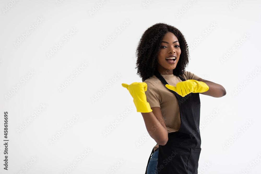 Young african housewife with rubber gloves and finger point aside isolated on white background Young african housewife with rubber gloves and finger point aside isolated on white background