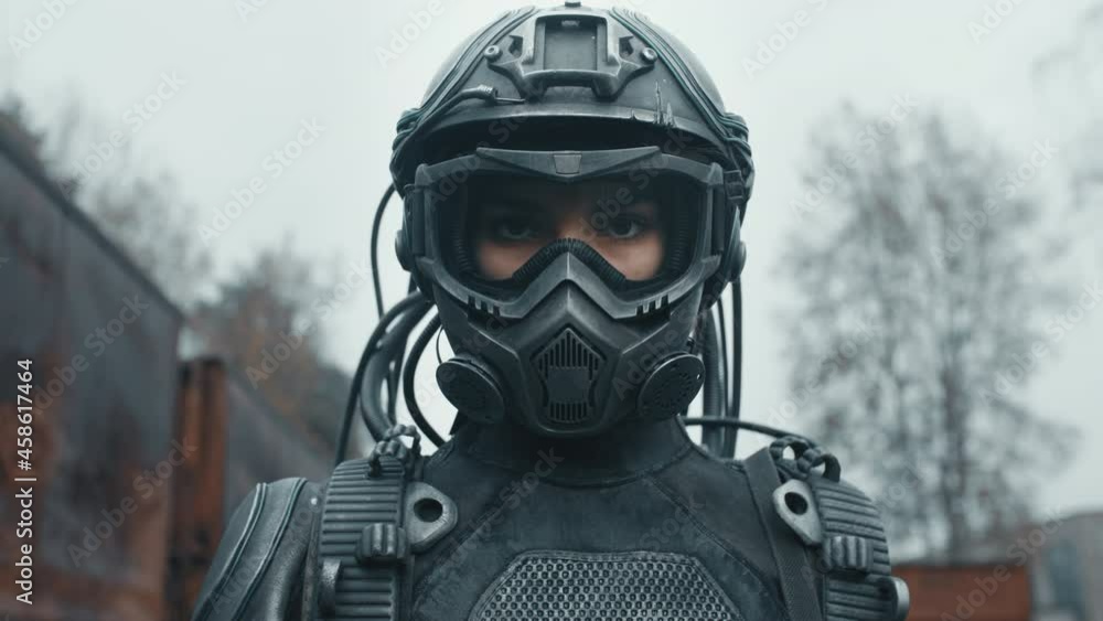 Portrait female future soldier in fiction helmet standing by rusty train carriage after nuclear war. Lonely star trooper cyborg girl in futuristic combat suit. Cyberpunk military post apocalypse Portrait female future soldier in fiction helmet standing by rusty train carriage after nuclear war. Lonely star trooper cyborg girl in futuristic combat suit. Cyberpunk military post apocalypse