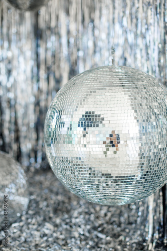 A mirror ball in a room decorated with silver decor. 