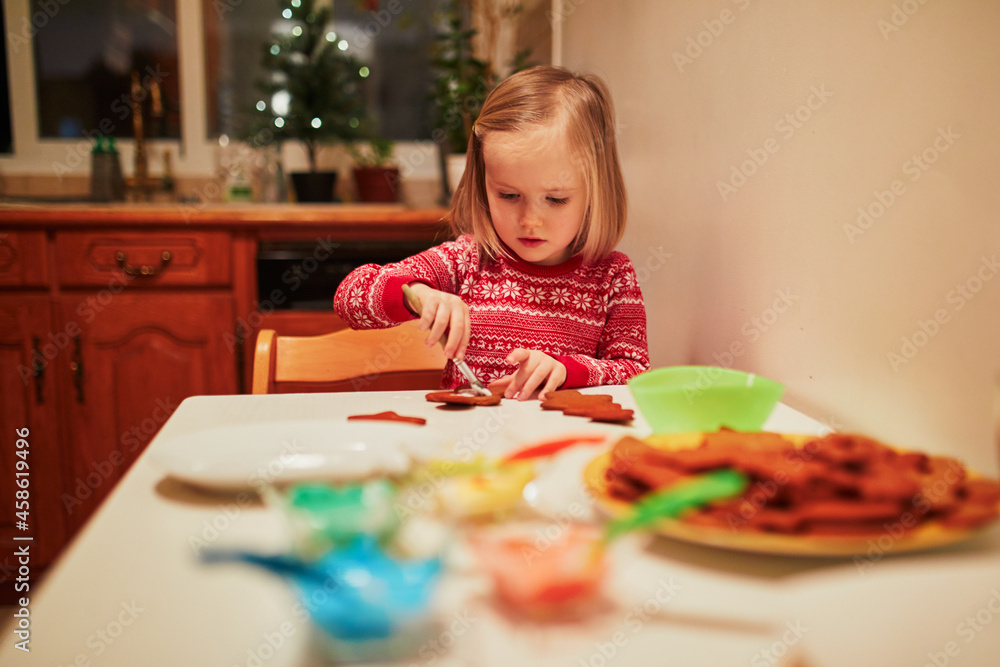 Adorable little preschooler girl cooking Christmas cookies Adorable little preschooler girl cooking Christmas cookies