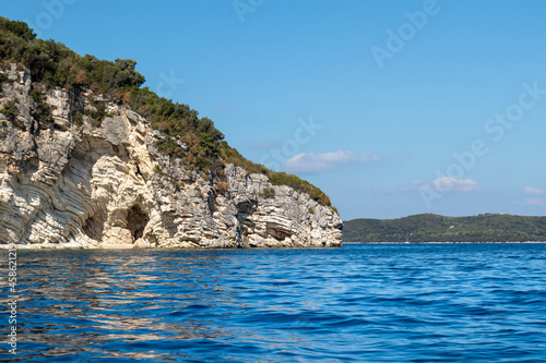 Fototapeta Naklejka Na Ścianę i Meble -  Blue vivid water of Ionian Sea with rocky white cliffs and clear sky. Nature of Lefkada island in Greece. Summer vacation travel destination
