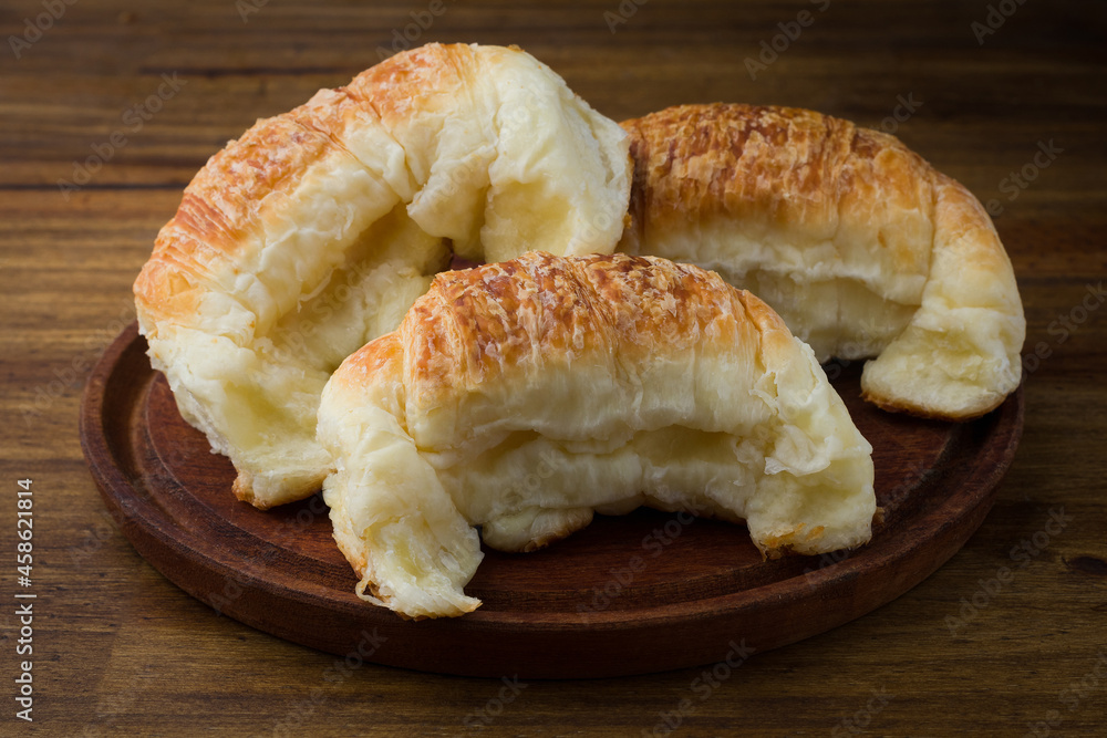 Freshly baked croissants on rustic plate on a dark wooden table. Delicious breakfast Freshly baked croissants on rustic plate on a dark wooden table. Delicious breakfast