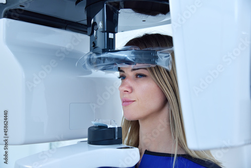 Woman patient make a x-ray picture on dental a tomograph in clinic