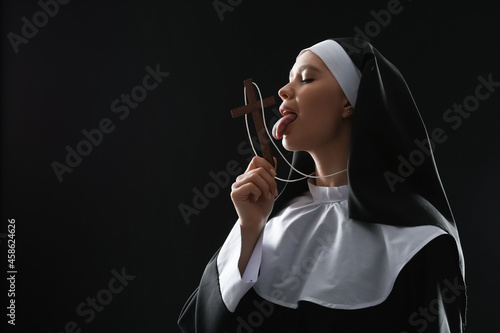 Slutty nun with cross on dark background