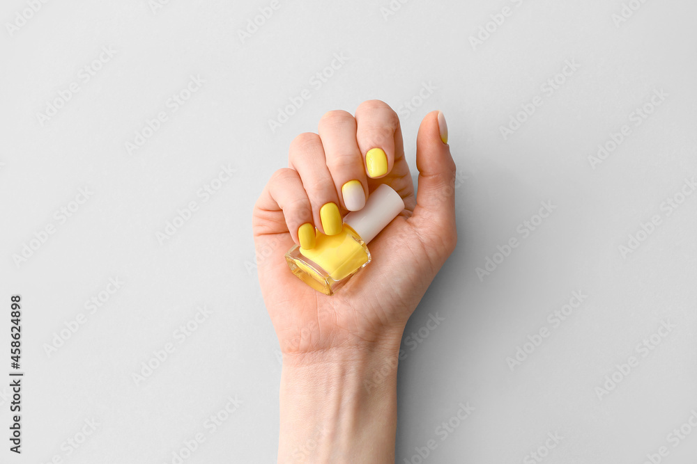 Female hand with beautiful manicure and nail polish on light background Female hand with beautiful manicure and nail polish on light background