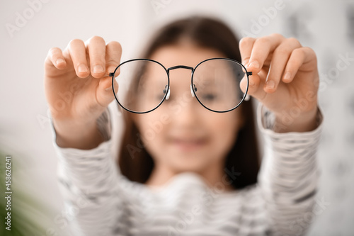 Fototapeta Naklejka Na Ścianę i Meble -  Little girl with new eyeglasses at ophthalmologist's office