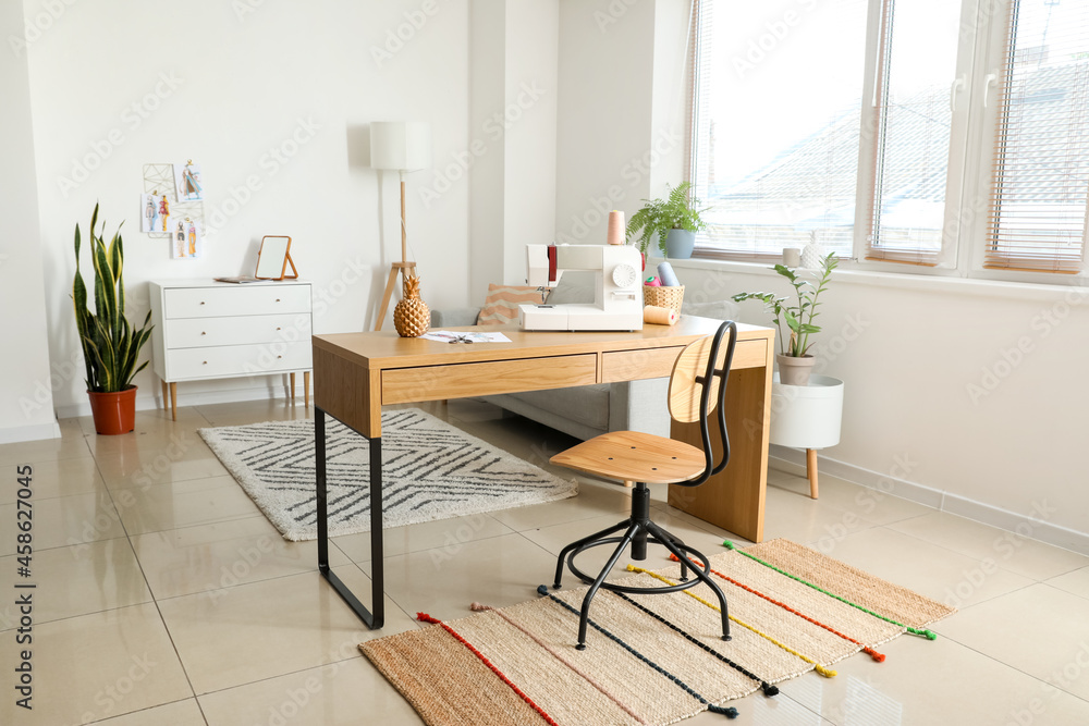 Fototapeta premium Modern home sewing studio with desk, sewing machine, and creative workspace for fashion design