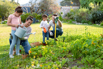 Happy caucasian family gardening and watering plants together