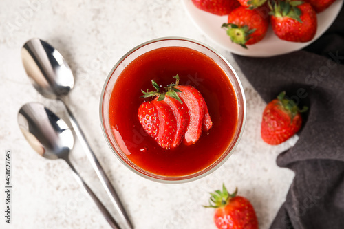 Delicious panna cotta with strawberry in glass on white background, closeup