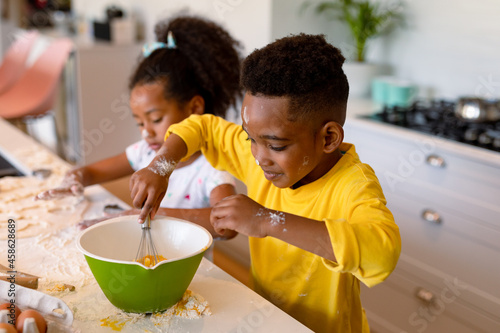 Canvas Print Happy african american siblings baking in kitchen