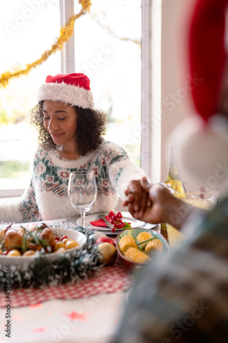African american woman and her partner holding hands over christmas table