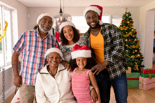 Happy multi generation family wearing santa hats, taking photo