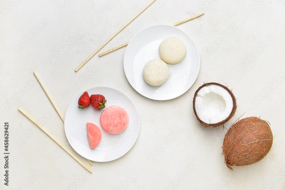 Plates with tasty Japanese mochi, coconut and chopsticks on light background Plates with tasty Japanese mochi, coconut and chopsticks on light background