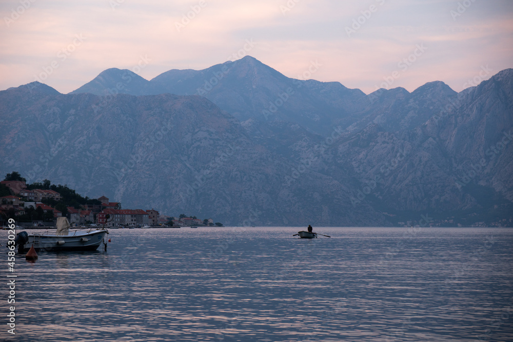Kotor / Montenegro - September 15 2021: View of a boat and the Kotor Bay at sunset, touristic famous destination in Montenegro, Europe