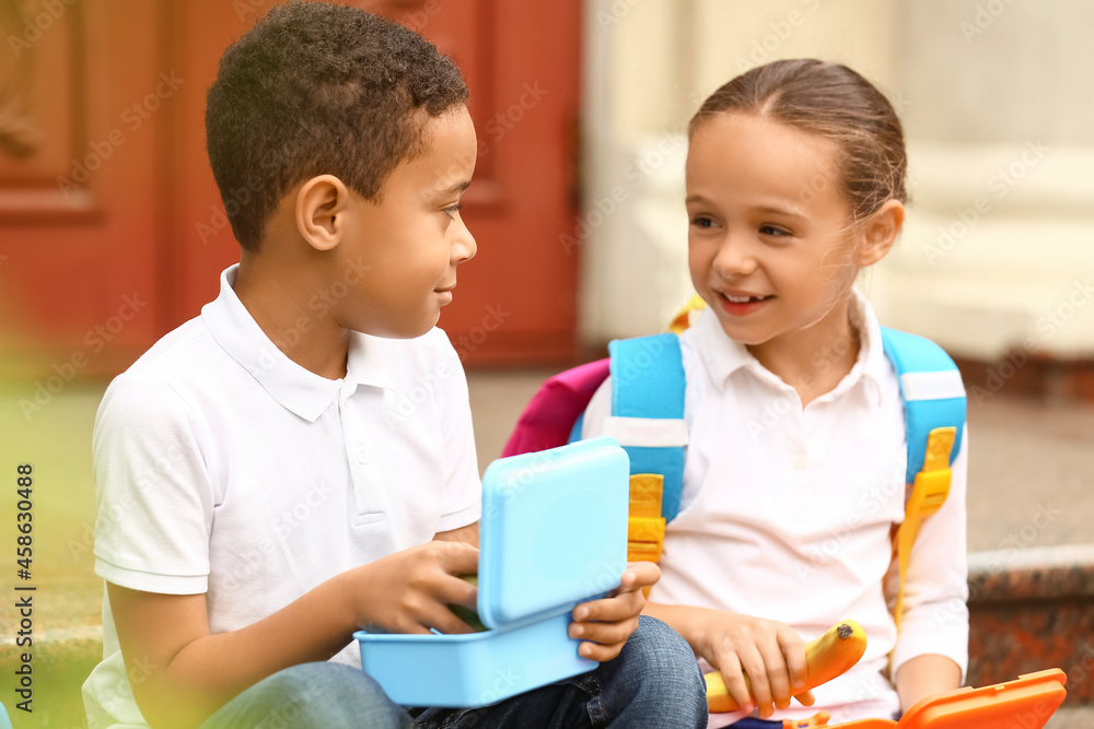 Obraz premium Cute little pupils having lunch outdoors