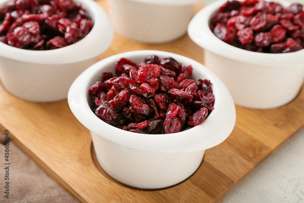 Bowls with tasty dried cranberries on table, closeup Bowls with tasty dried cranberries on table, closeup