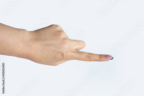 Photography MENO FEMENINA CON MANICURE SEÑALANDO CON EL DEDO INDICE SOBRE FONDO BLANCO