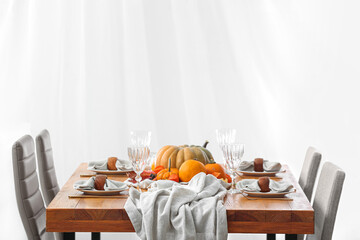 Stylish served wooden table with autumn decor in light room