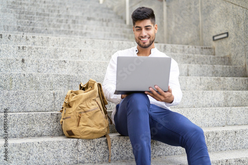 handsome young man working with laptop on stairs. High quality photo © herraez