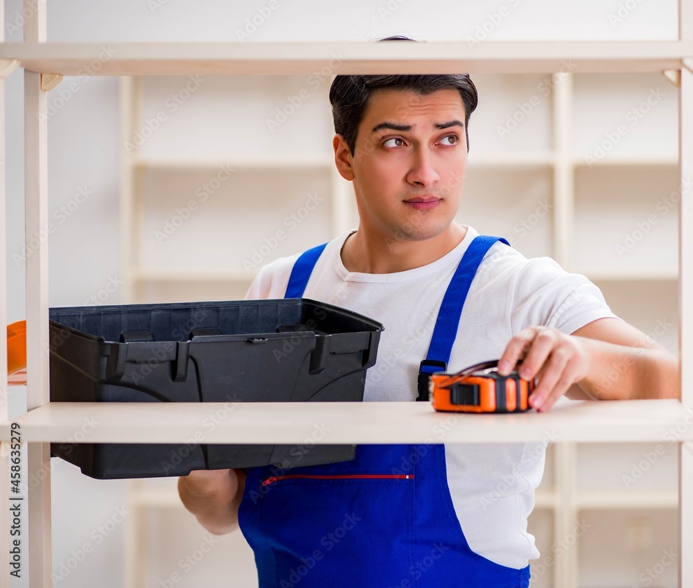 Worker man repairing assembling bookshelf Worker man repairing assembling bookshelf