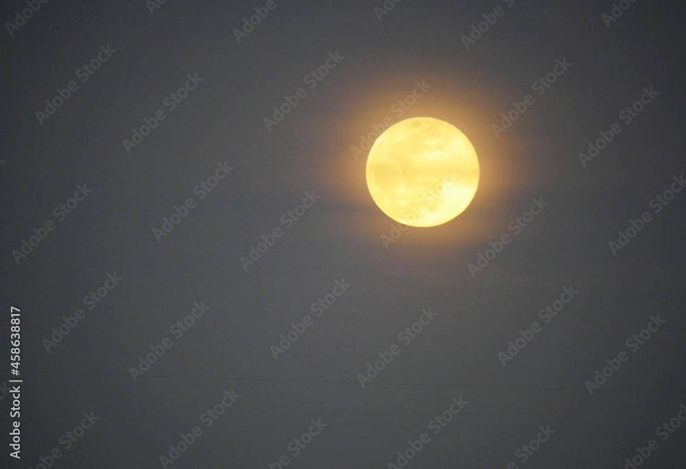 Yellowish full moon in the skies, medium wide shot Yellowish full moon in the skies, medium wide shot