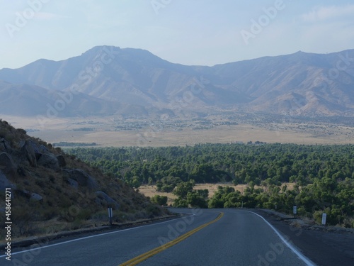 Winding sloping road with distant mountains in the background, Kern County, California. © raksyBH
