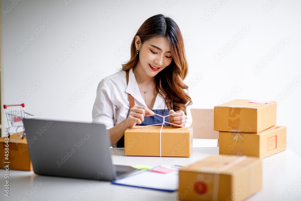 Portrait of Starting small businesses SME owners female entrepreneurs working on receipt box and check online orders to prepare to pack the boxes, sell to customers, sme business ideas online. Portrait of Starting small businesses SME owners female entrepreneurs working on receipt box and check online orders to prepare to pack the boxes, sell to customers, sme business ideas online.