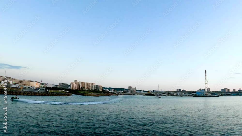 夕方、港に停泊するヨットやクルーザーそれを照らす太陽。逆光が生み出す美しい景色。