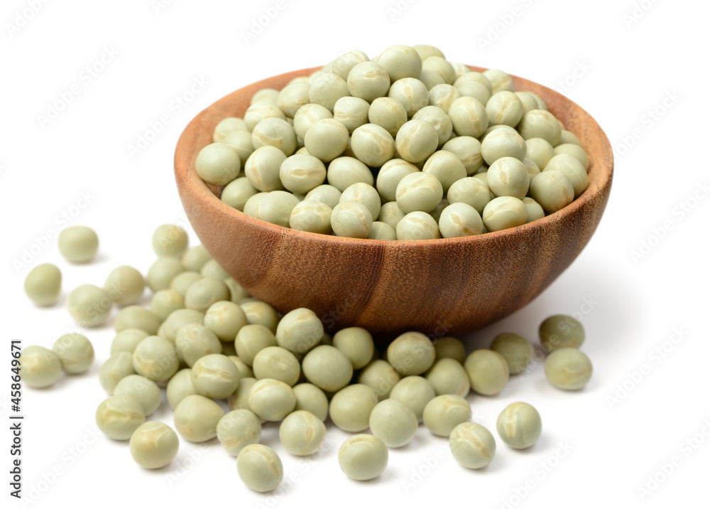 uncooked dried green peas in the wooden bowl, isolated on the white background uncooked dried green peas in the wooden bowl, isolated on the white background